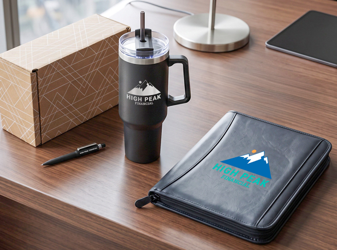 Custom financial services promotional products like an engraved tumbler, leather padfolio, and pen