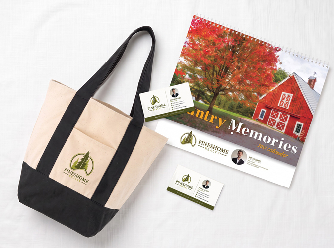 Real estate promotional products like a branded tote bag, wall calendar, and business cards